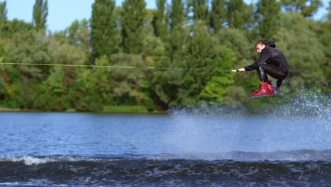Wakeboarder-jumping-over-water-wave.-Slim-man-wakeboarding-above-water