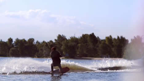 Man-wakeboarding-on-waves.-Water-skiing-on-lake-behind-boat.-Wakeboarder-surfing