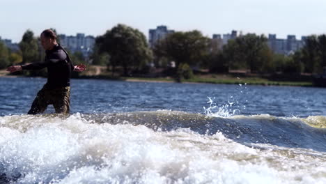 Sporty-man-wakeboarding-on-river.-Young-sportsman-wake-surfing-on-waves