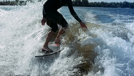 Man-riding-surf-on-waves-of-river.-Wakesurfing-sport.-Extreme-lifestyle