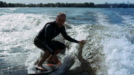 Sportsman-wake-surfing-on-waves-in-slow-motion.-Rider-making-wake-surf-stunt