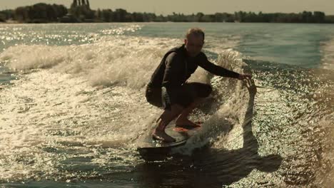 Man-surfing-on-waves-in-slow-motion.-Wake-surfing-rider-enjoy-waves