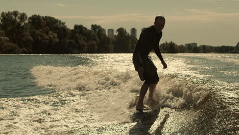 Man-surfing-on-waves.-Sportive-man-surfing-on-wakeboard-in-slow-motion