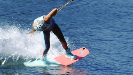 Young-woman-riding-wakeboard-on-summer-river.-Entertainment-on-water-of-river