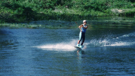 Pretty-girl-wakeboarding-on-summer-river.-Woman-practicing-water-skiing