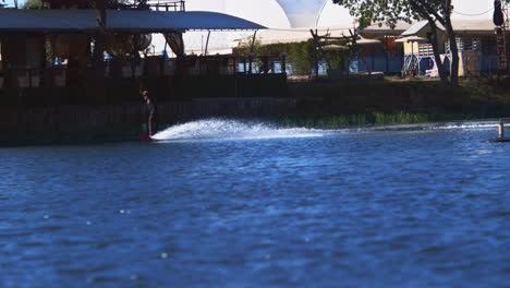 Sportler-Trainieren-Wakeboarden-Auf-Der-Wasseroberfläche-Eines-Modernen-Wasserskikomplexes