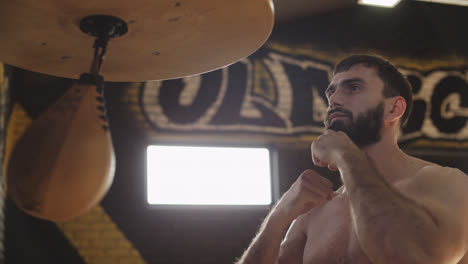 Bearded-boxer-training-with-speed-bag.-Young-boxer-practicing-punches