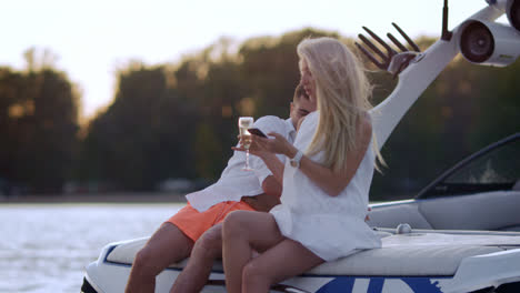 Luxury-vacation-on-yacht-on-lake.-Young-people-boating-on-yacht-at-sunset