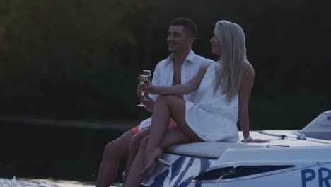 Young-people-toasting-with-champagne-glasses-on-motor-boat.-Romantic-dating