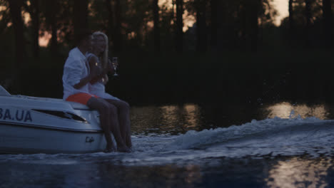 Young-people-drinking-champagne-on-floating-motor-boat.-Boating-on-river