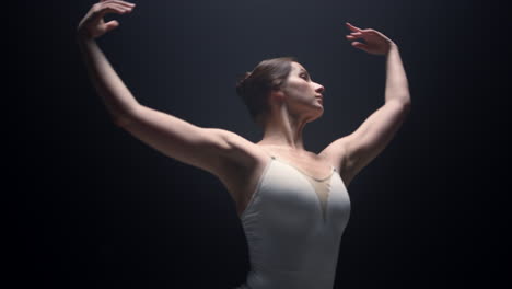 Sensual-dancer-performing-with-raised-hands-indoors.-Ballerina-dancing-in-class