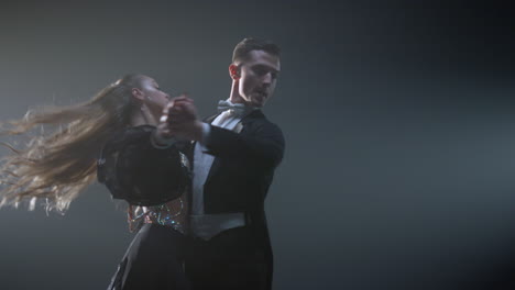 Ballroom-dance-couple-twirling-in-dark-space.-Elegant-man-and-woman-dancing.