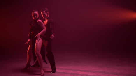 Full-length-professional-couple-dancing-indoors.-Dancers-moving-sensually.