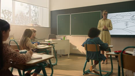 Schoolchildren-sitting-at-desks-in-classroom.-Schoolteacher-teaching-students