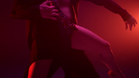 Unknown-couple-feet-dancing-in-dark-hall.-Sensual-dancers-doing-support-indoors.