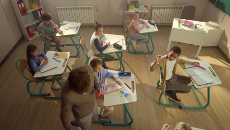 Diverse-group-of-children-having-lesson-in-classroom-with-teacher