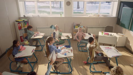 Kids-playing-with-paper-planes-in-classroom.-Schoolchildren-having-fun