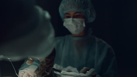 Surgeon-hands-suturing-patient-closeup.-Team-finish-medical-operation-hospital.