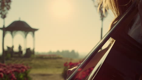 Bright-sun-beams-through-woman-profile-playing-music-in-blossomed-park-outdoors.
