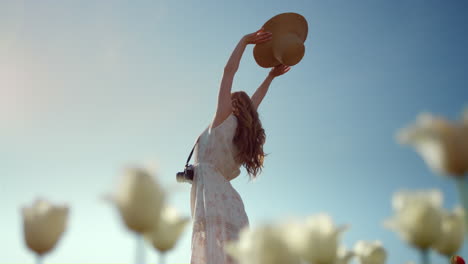 Unknown-woman-silhouette-with-sunhat-stretching-hands-to-blue-sky-in-sunny-day.