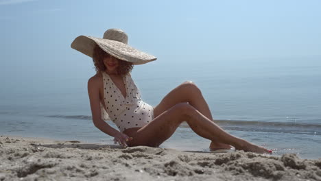 Elegantes-Mädchen,-Das-Den-Sandstrand-Im-Badeanzug-Berührt.-Glückliche-Frau-Beim-Sonnenbaden.