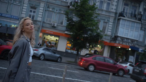 Happy-woman-walking-city-at-late-evening-on-urban-background.