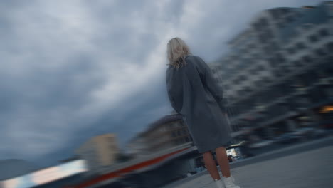 Blonde-woman-standing-buildings-at-rainy-city-at-evening-urban-area.