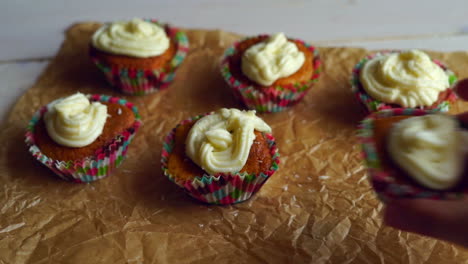 Chef-take-away-one-cupcake.-Six-cupcakes-on-cooking-paper