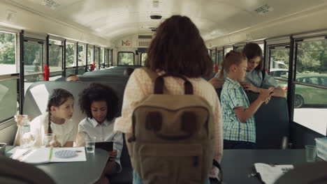 Teenage-pupils-boarding-school-bus.-Diverse-children-using-gadgets-in-vehicle.